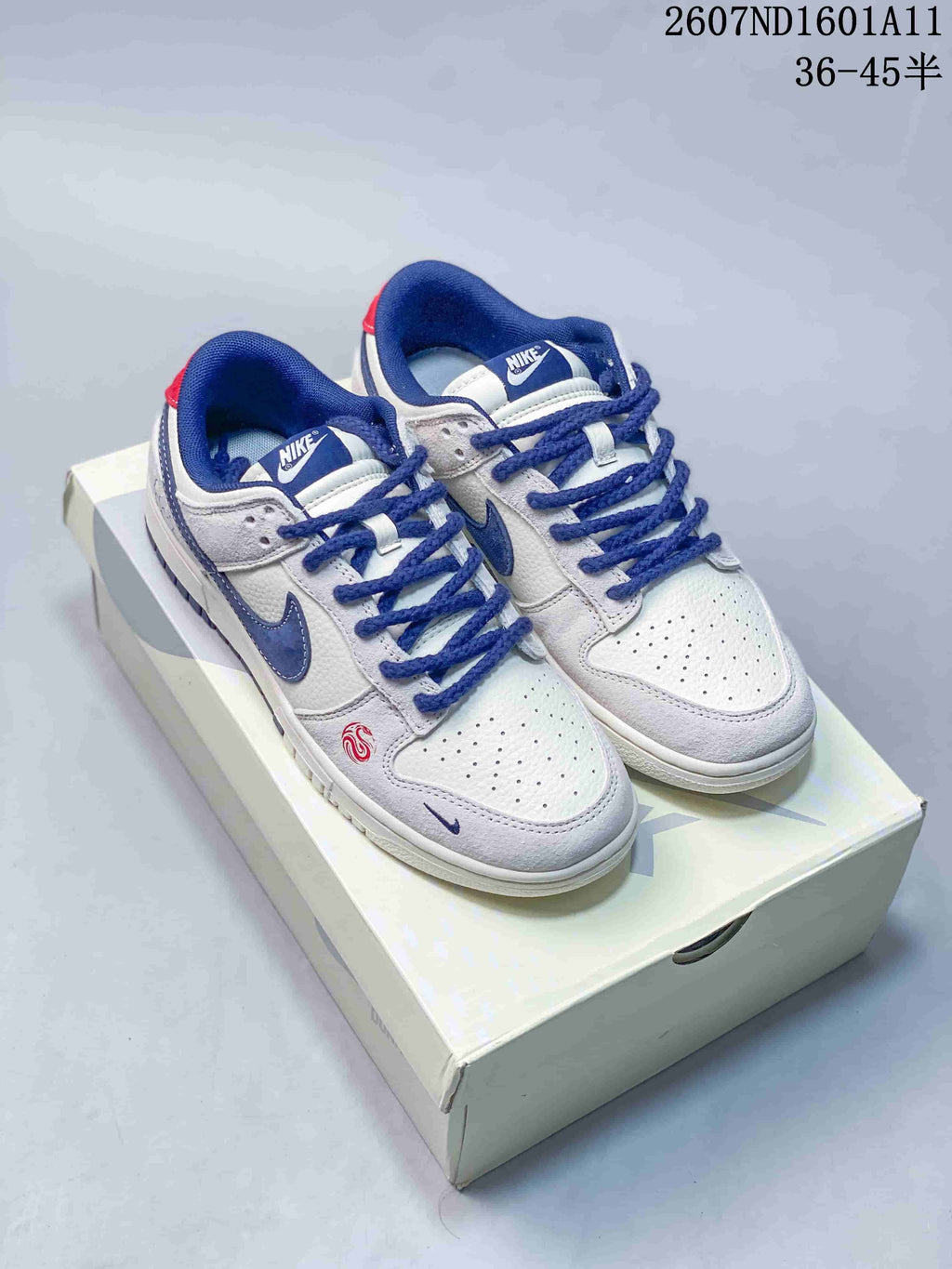 Nike SB Dunk Low Sneakers in White and Blue 2607ND1601A11 - product image from the listing.