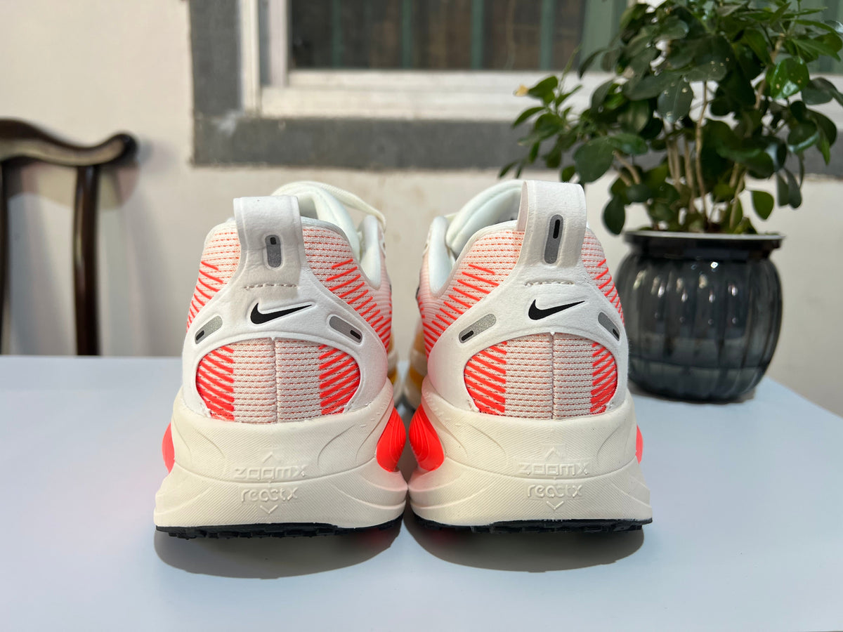 Nike Vomero 18 Running Shoes, in White and Coral - product image from the listing.