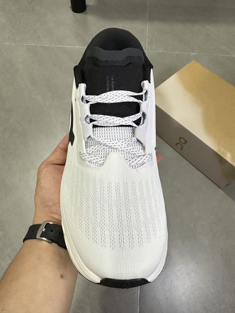 On Running Running Shoes in White and Black - product image from the listing.