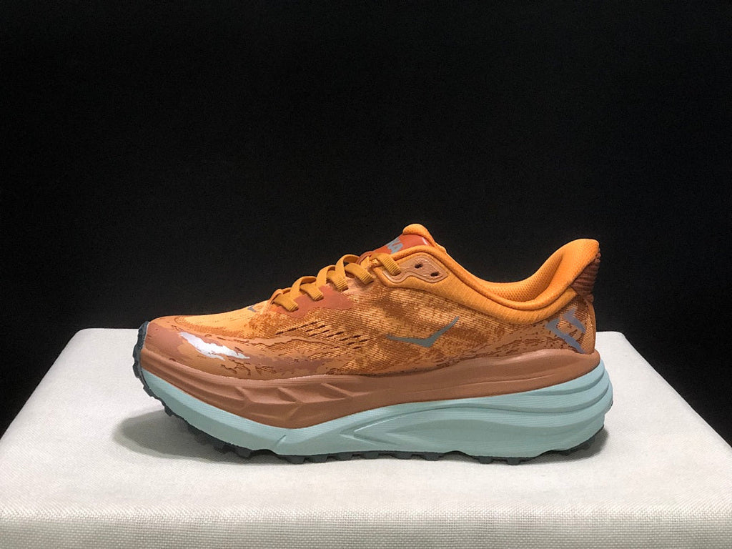 Orange HOKA Stinson 7 Trail Running Shoes - product image from the listing.