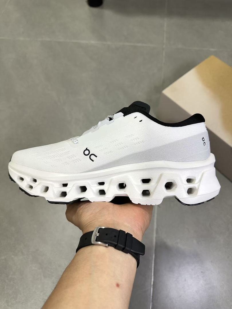 On Running Running Shoes in White and Black - product image from the listing.