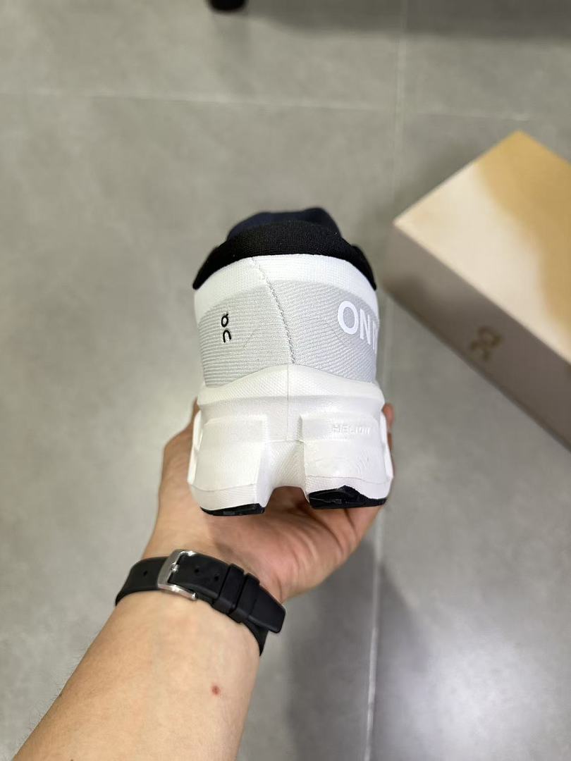 On Running Running Shoes in White and Black - product image from the listing.