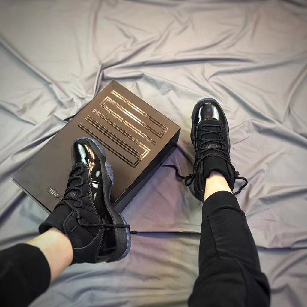 Air Jordan 11 Cap and Gown High-Top Sneakers in Black - product image from the listing.