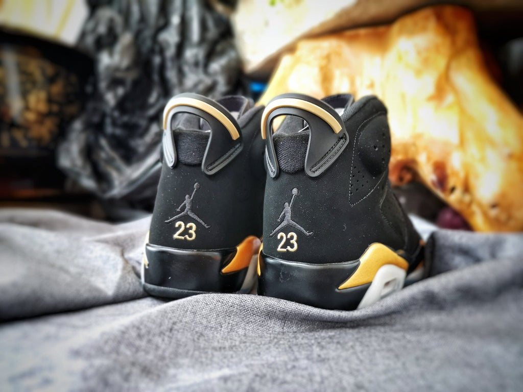 Air Jordan 6 High-Top Sneakers in Black and Gold - product image from the listing.
